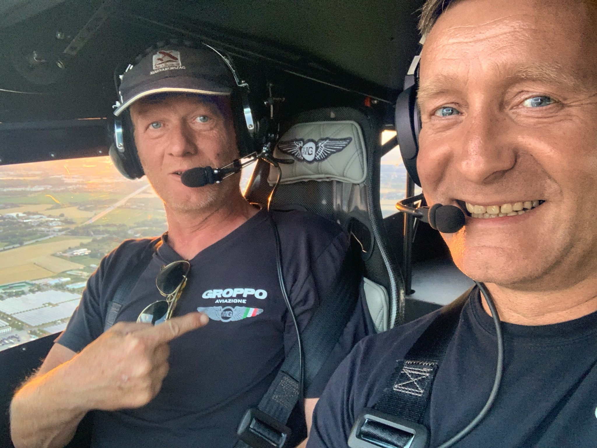 Zwei Piloten mit Headsets im Flugzeugcockpit lächeln