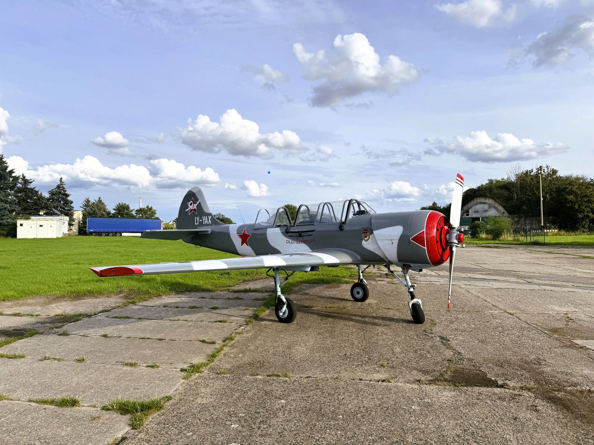 Graues Propellerflugzeug mit roten Sternen auf Flughafenroll