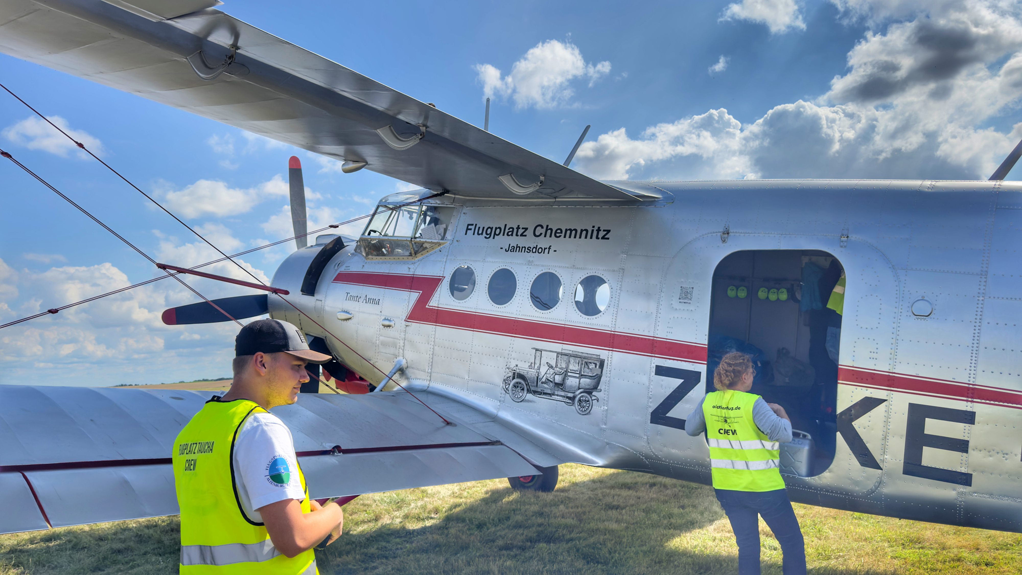 Crewmitglieder bereiten ein Oldtimer-Flugzeug am Flugplatz Chemnitz-Jahnsdorf für den Flug vor