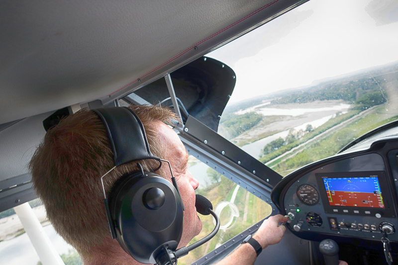 Pilot steuert Kleinflugzeug mit Headset im Cockpit